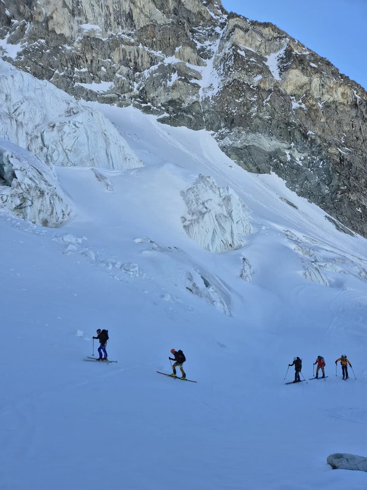 Eine Gruppe mit Bergführer im Aufstieg unter dem Gletscherbruch des Glacier des Serpentine während der Haute Route